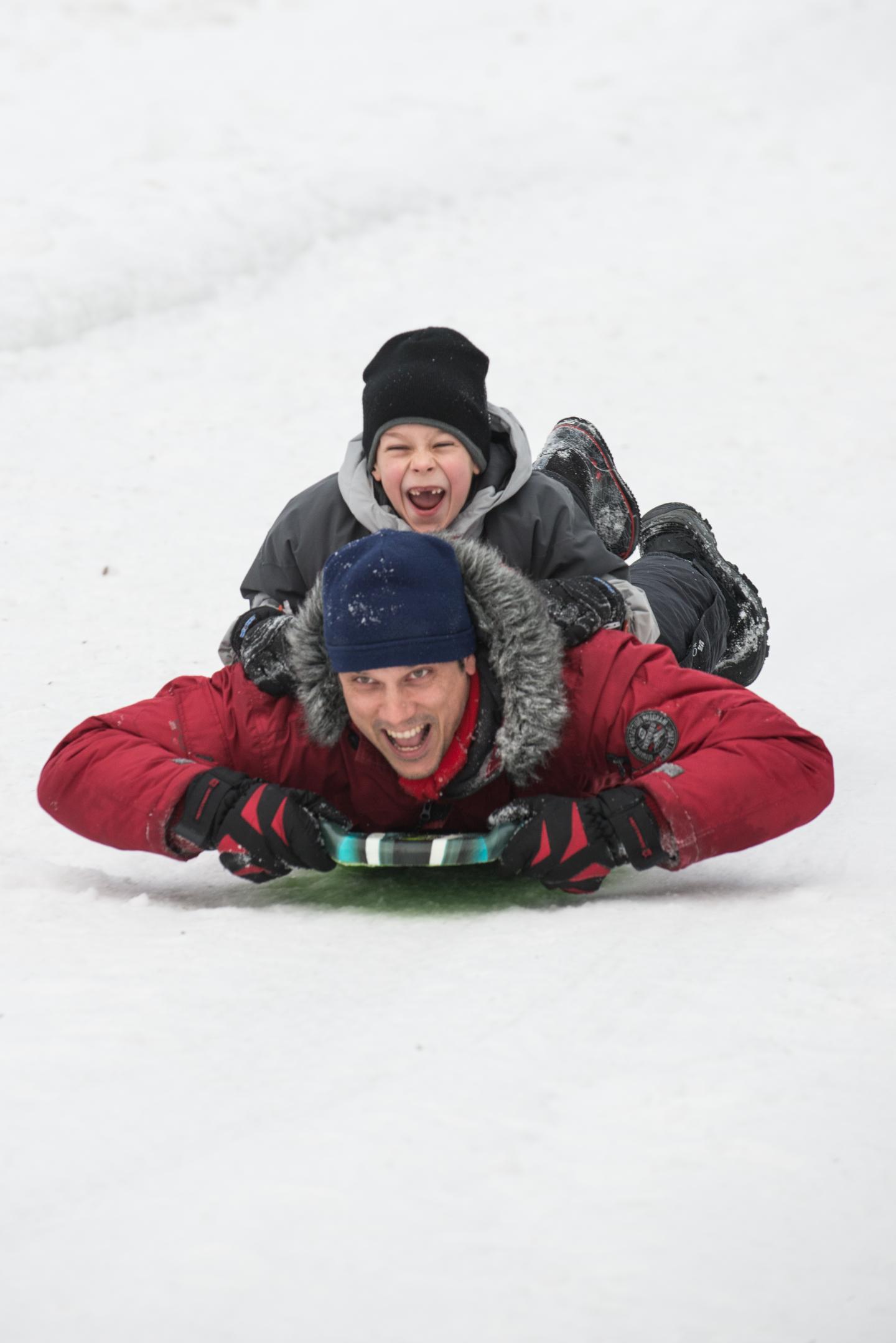 Adult and child tobogganing